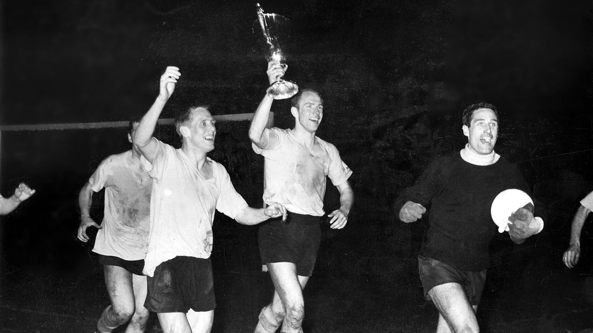 Hans Tilkowski, Wolfgang Paul und Sigi Held (v.r.n.l) laufen eine Ehrenrunde mit dem Pokal